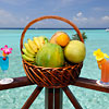 Photo d'un panier de fruits garni et cocktails en guise de bienvenue aux Maldives